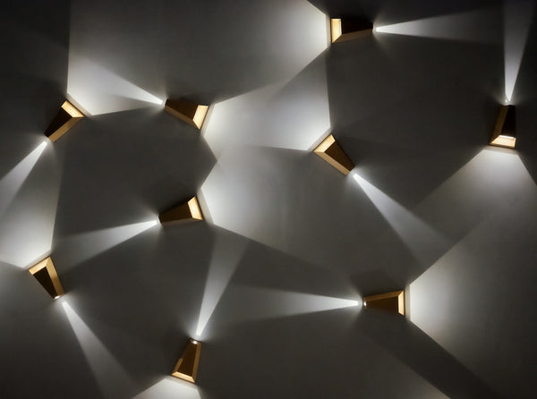 Modern wall sconces casting light patterns on wall